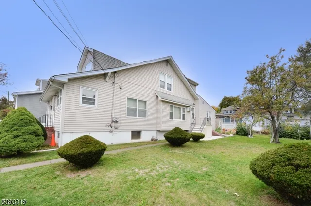 a backyard of a house with potted plants and large tree