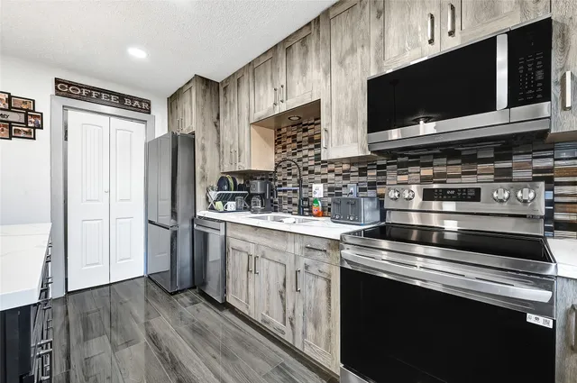 a kitchen with stainless steel appliances a stove microwave and refrigerator