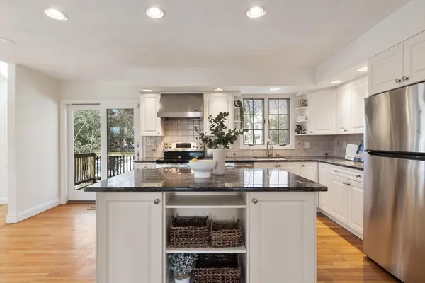 a kitchen with stainless steel appliances granite countertop a refrigerator a stove a sink and a microwave