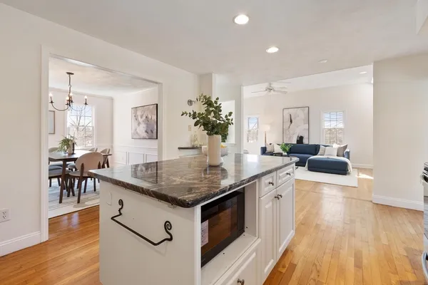 a living room with stainless steel appliances granite countertop wooden floor and sink