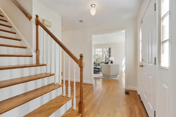 a view of an entryway with wooden floor and a livingroom view