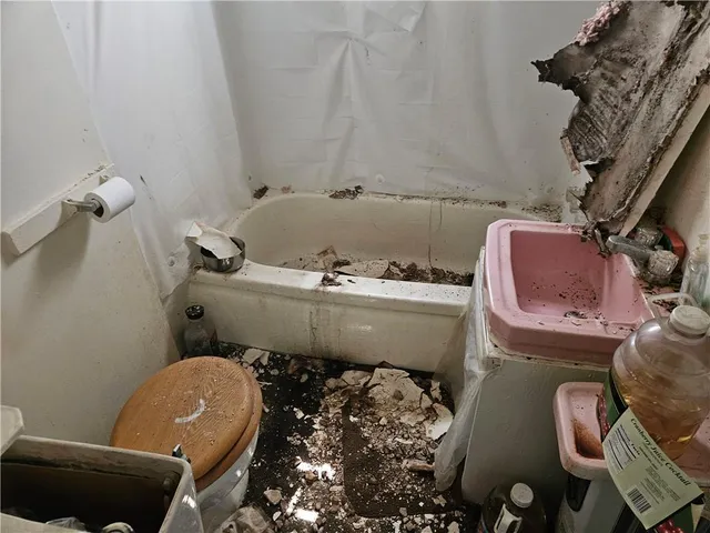 a living room with furniture a flat screen tv and a window