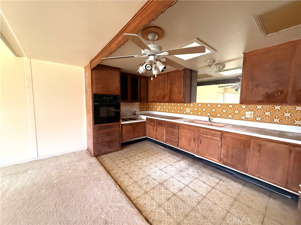 1621 Monterey Road, Unit 19H Seal Beach, CA 90740 - Photo 6 of 10 a kitchen with stainless steel appliances granite countertop a sink and a refrigerator