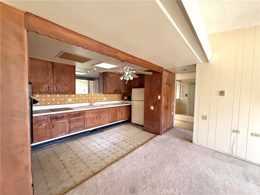 1621 Monterey Road, Unit 19H Seal Beach, CA 90740 - Photo 7 of 10 a large room with kitchen island granite countertop a sink and white cabinets