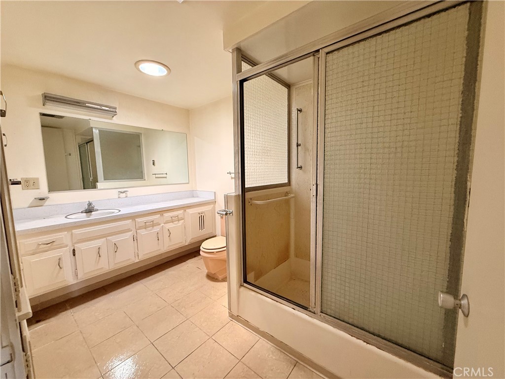 1621 Monterey Road, Unit 19H Seal Beach, CA 90740 - Photo 8 of 10 a bathroom with a double vanity sink mirror and shower