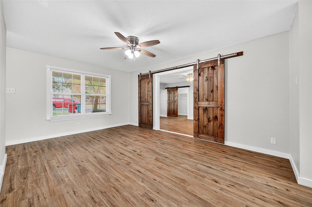 218 Kansas Street Sherman, TX 75090 - Photo 4 of 22 a view of an empty room with wooden floor and a window