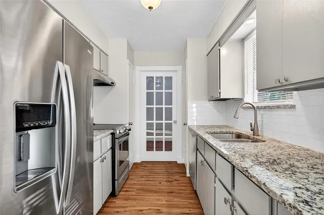 a kitchen with stainless steel appliances granite countertop a refrigerator and a sink