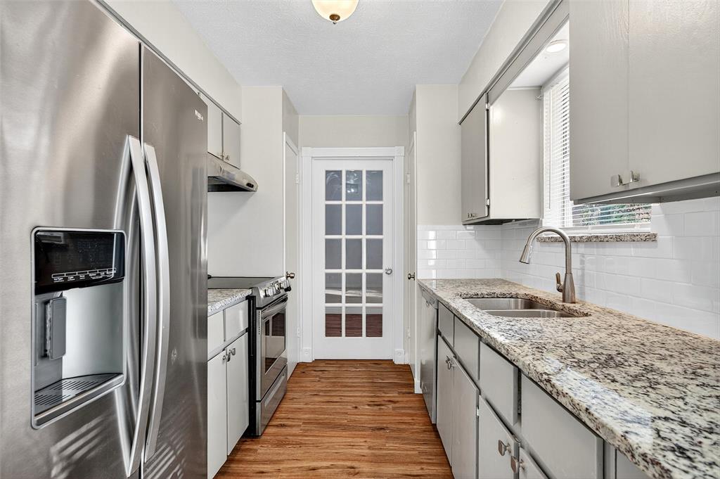 218 Kansas Street Sherman, TX 75090 - Photo 7 of 22 a kitchen with stainless steel appliances granite countertop a refrigerator and a sink