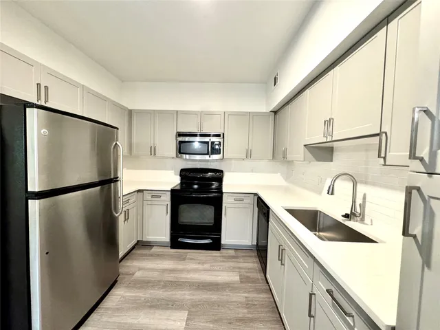 a kitchen with a refrigerator sink and stove