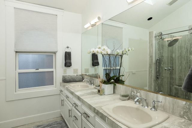 a bathroom with a double vanity sink mirror and shower