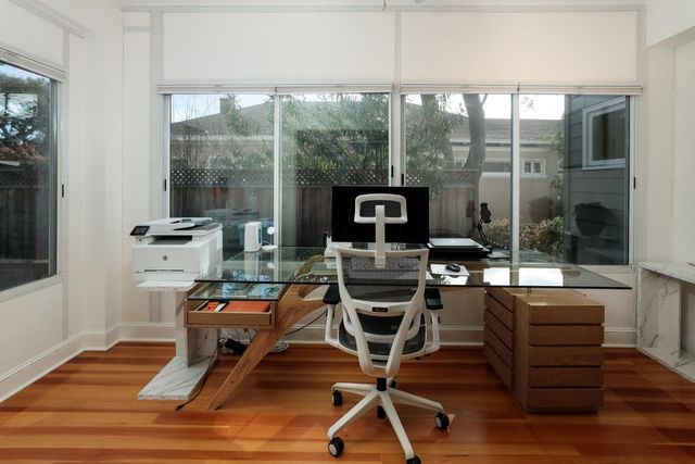 a view of a workspace with furniture and a window