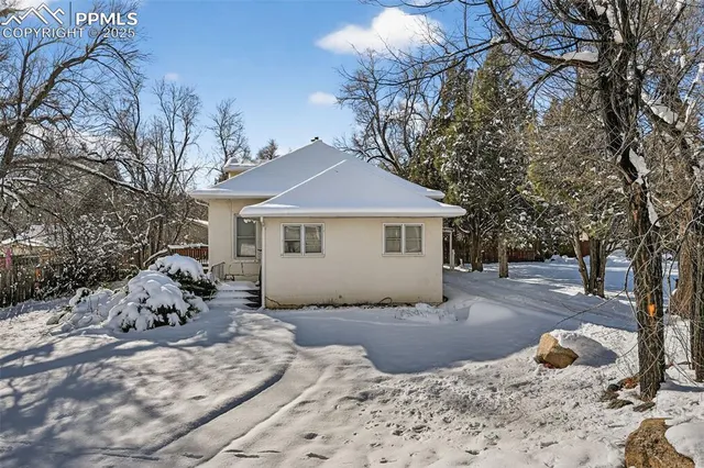 a front view of a house with a yard covered in snow