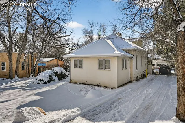a white house that has a tree in front of it