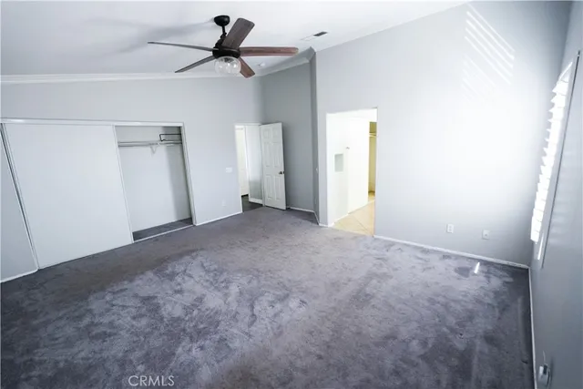 a view of a room with a ceiling fan and entryway