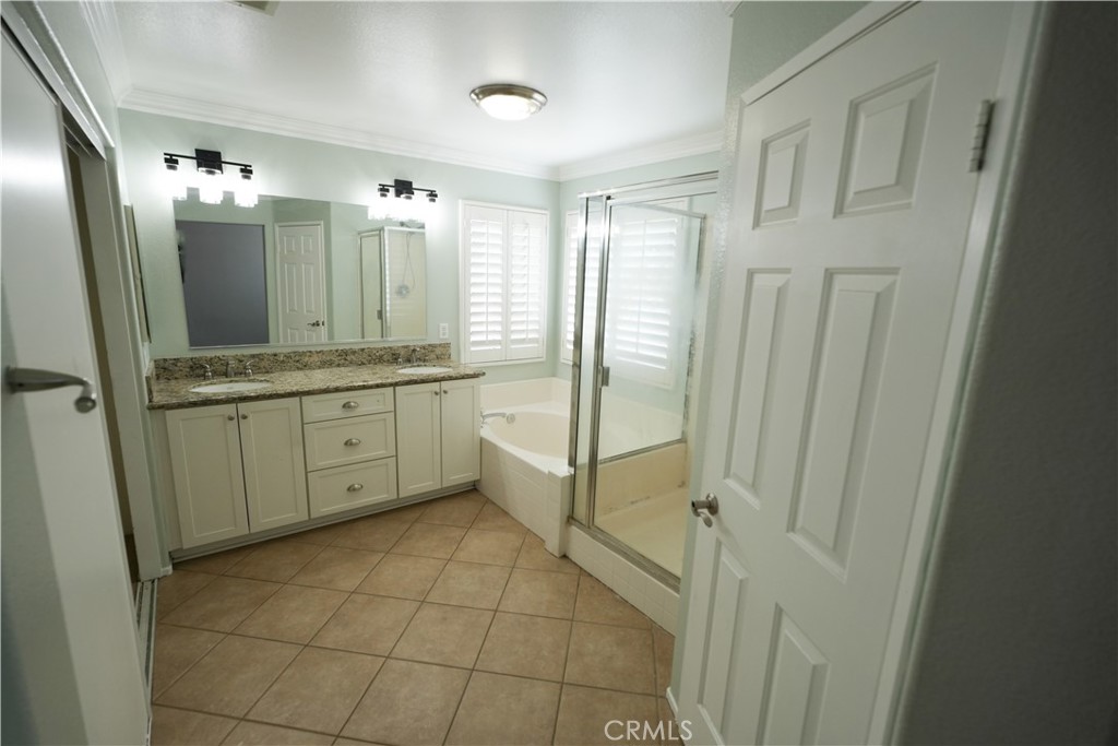 1464 Augusta Street Beaumont, CA 92223 - Photo 13 of 32 a bathroom with a mirror a sink and glass door