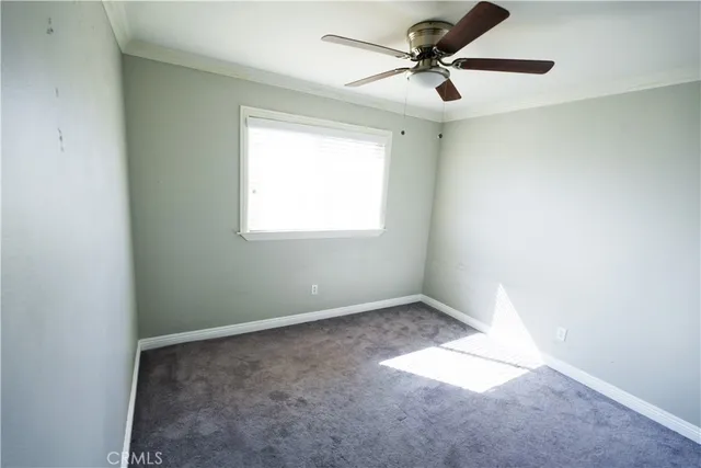 an empty room with ceiling fan and window