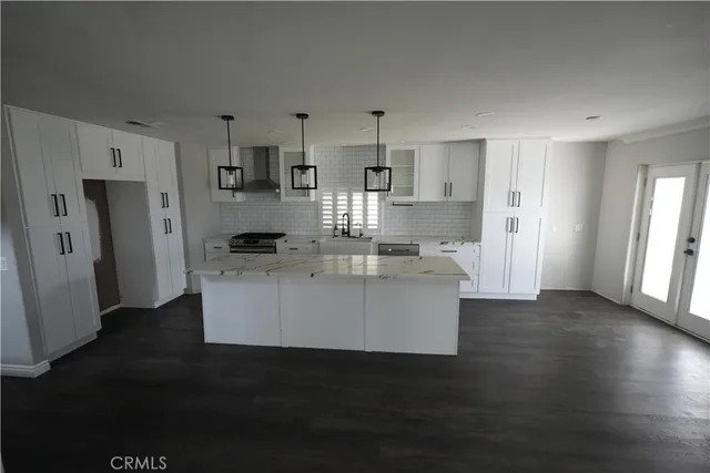 a view living room with stainless steel appliances kitchen island granite countertop a refrigerator and a stove