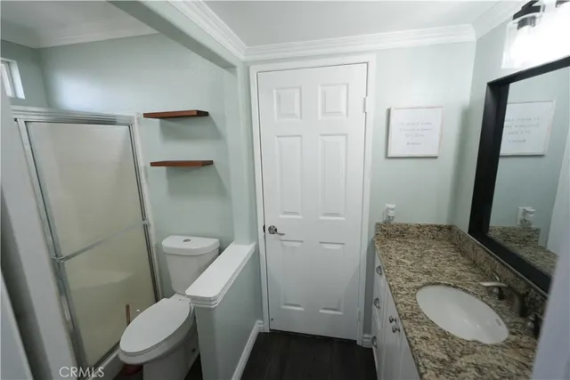 a white toilet sitting next to a bathroom sink and a mirror