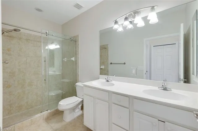 a bathroom with a toilet a sink and a large mirror