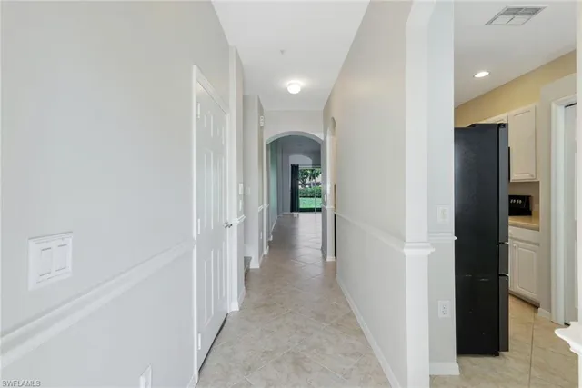 a view of a hallway with white walls and door