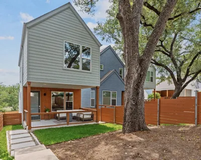 a view of a house with a yard and large tree