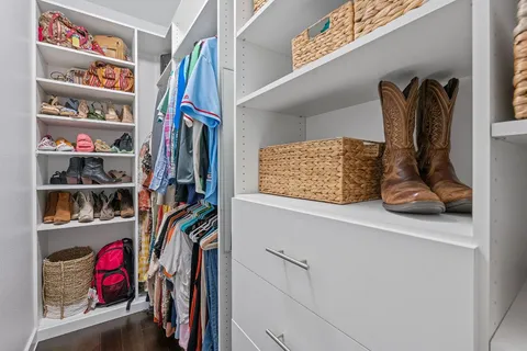 a view of walk in closet with clothes and shoes