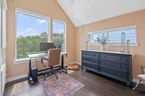 a view of a workspace with furniture and a window