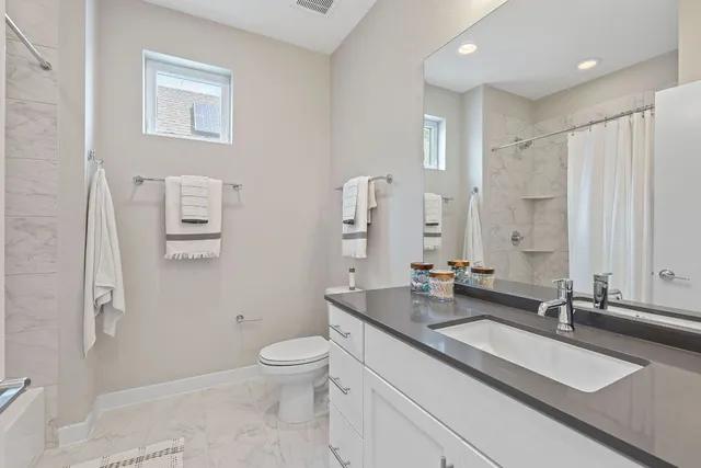 a bathroom with a double vanity sink toilet and a mirror