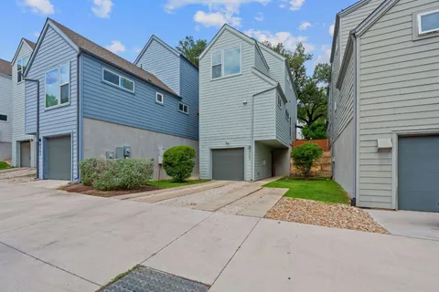 a front view of a house with a yard and potted plants
