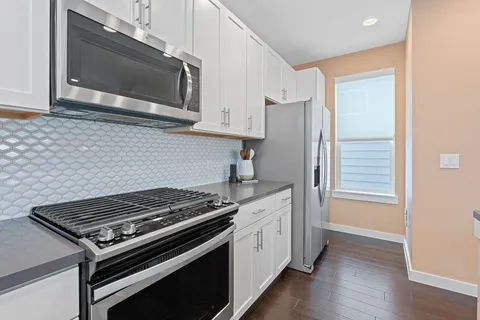 a kitchen with stainless steel appliances a stove a microwave and cabinets