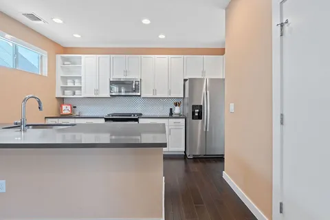a kitchen with stainless steel appliances granite countertop a refrigerator and a stove top oven
