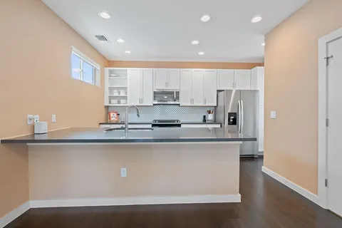 a kitchen with stainless steel appliances granite countertop a sink a stove and a refrigerator