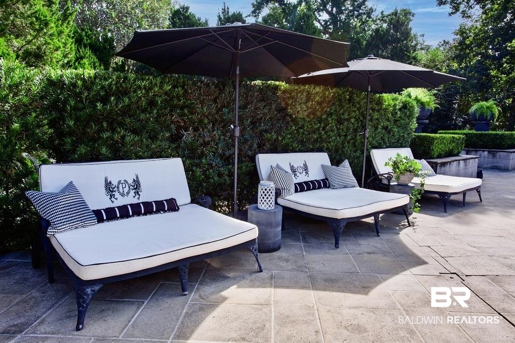 150 Austill Avenue Mobile, AL 36608 - Photo 37 of 39 Expansive stone patio featuring mature, sculpted hedges and a tiered planter with greenery