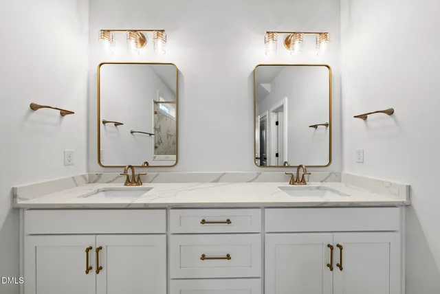 a bathroom with double vanity sinks and a mirror