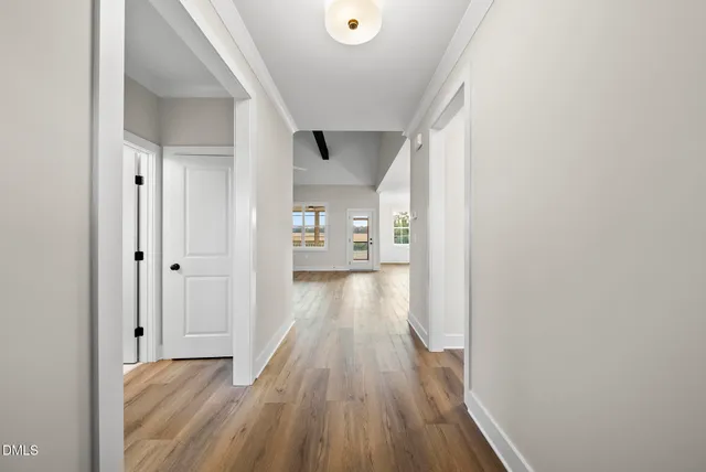 a view of a hallway with wooden floor and staircase