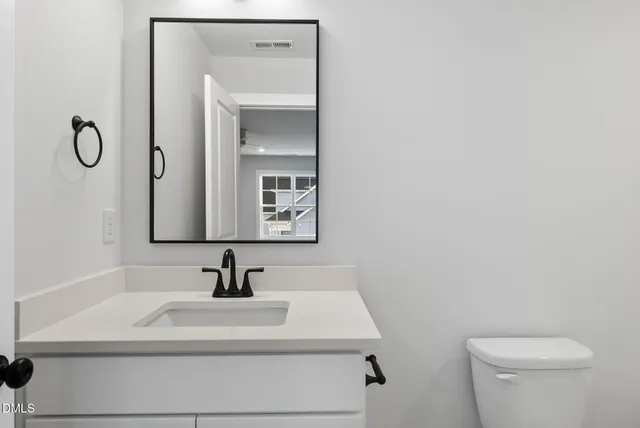 a bathroom with a sink a toilet and mirror
