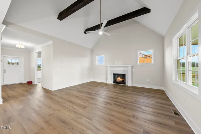 a view of empty room with wooden floor and fireplace