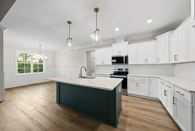 a kitchen with stainless steel appliances granite countertop a sink dishwasher a stove and a oven with wooden floor