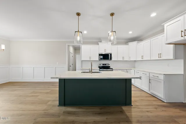 a kitchen with kitchen island a sink a stove and cabinets
