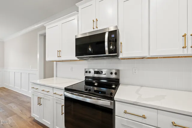 a kitchen with microwave cabinets and stove top oven