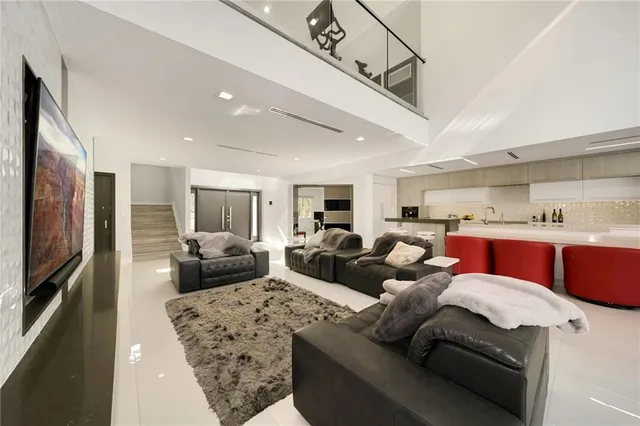 a living room with furniture kitchen view and a flat screen tv