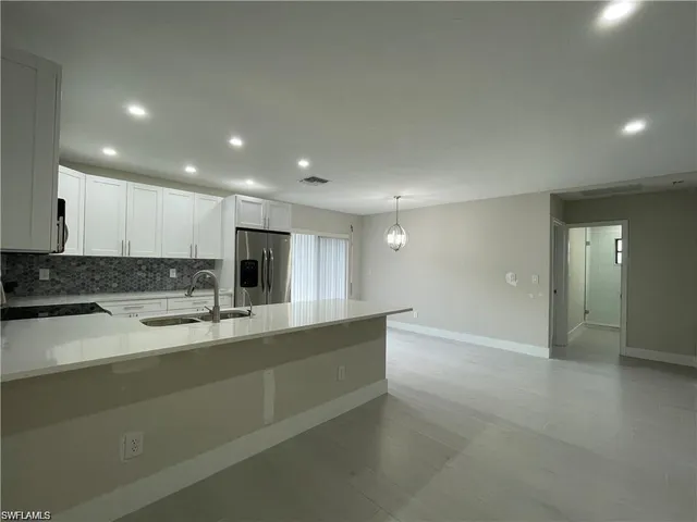a view of a kitchen with a sink and dishwasher with wooden floor