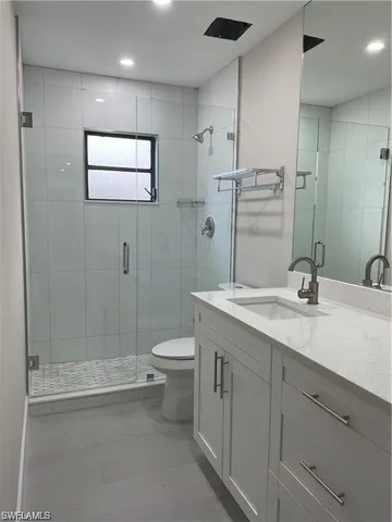 a bathroom with a double vanity sink toilet and shower