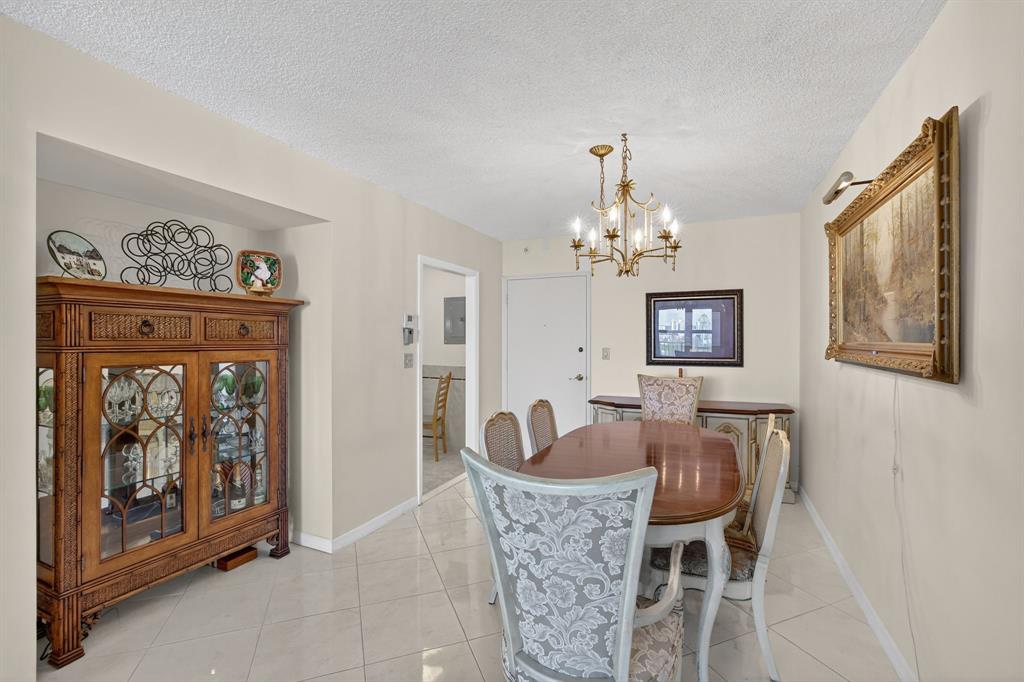 405 North Ocean Boulevard, Unit 1027 Pompano Beach, FL 33062 - Photo 38 of 57 a dining room with furniture and chandelier