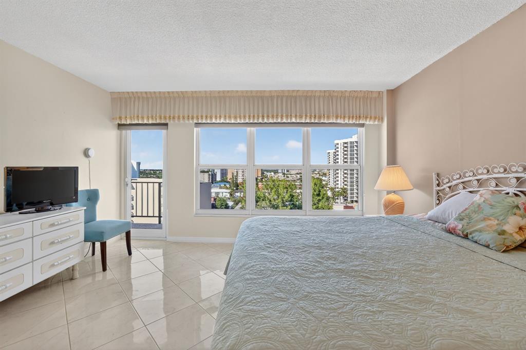 405 North Ocean Boulevard, Unit 1027 Pompano Beach, FL 33062 - Photo 44 of 57 a bedroom with a bed and glass windows