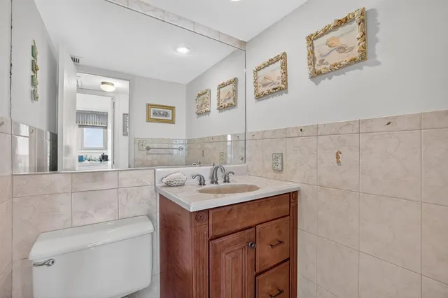 a bathroom with a sink a toilet and shower a mirror