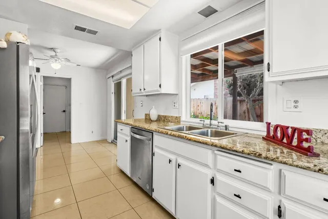 a kitchen with granite countertop a sink stainless steel appliances and cabinets