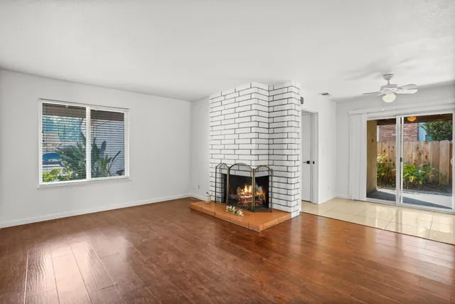 an empty room with windows and fireplace