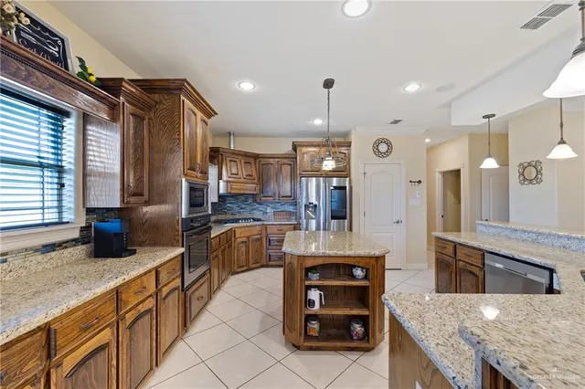 a kitchen with stainless steel appliances granite countertop a sink and a refrigerator