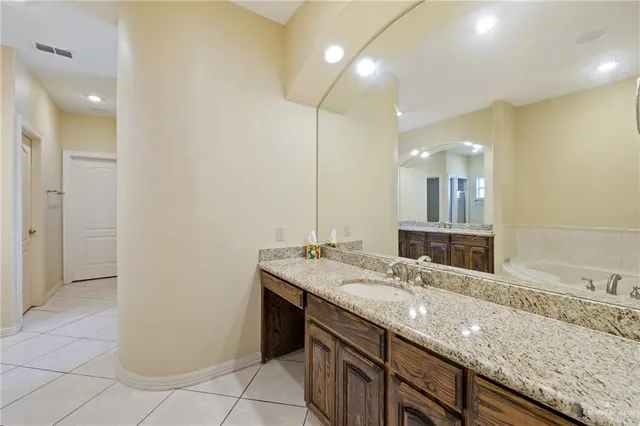 a bathroom with a granite countertop sink and a mirror